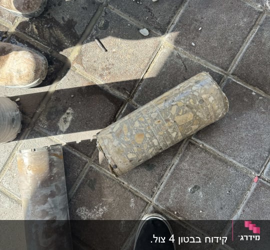 גליל בטון שנשלף בקידוח יהלום לצד כוס קידוח על הרצפה